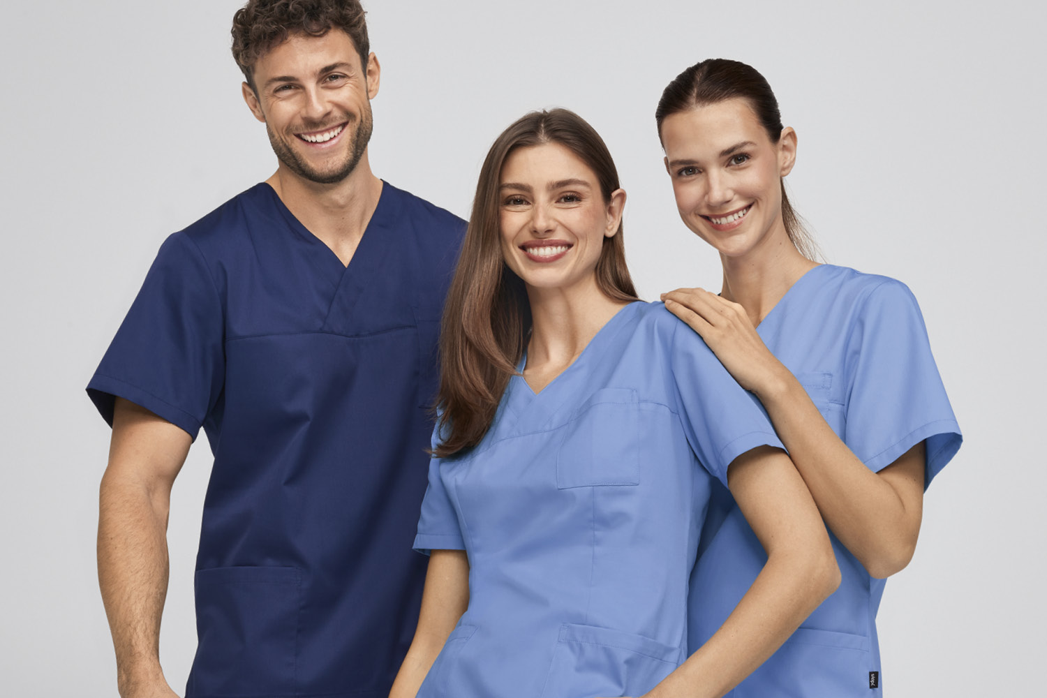 Tre personer i 7days arbejdstøj kigger ind i kameraet