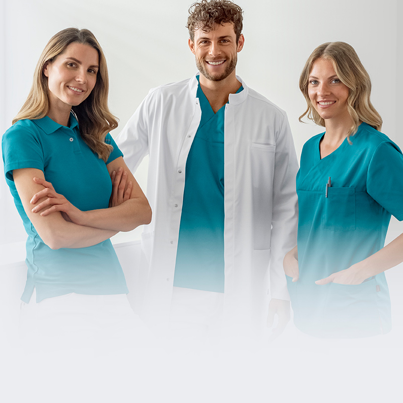 En mand i lægefrakke og turkis tunika og to kvinder i turkis poloshirts og tunikaer i en praksis